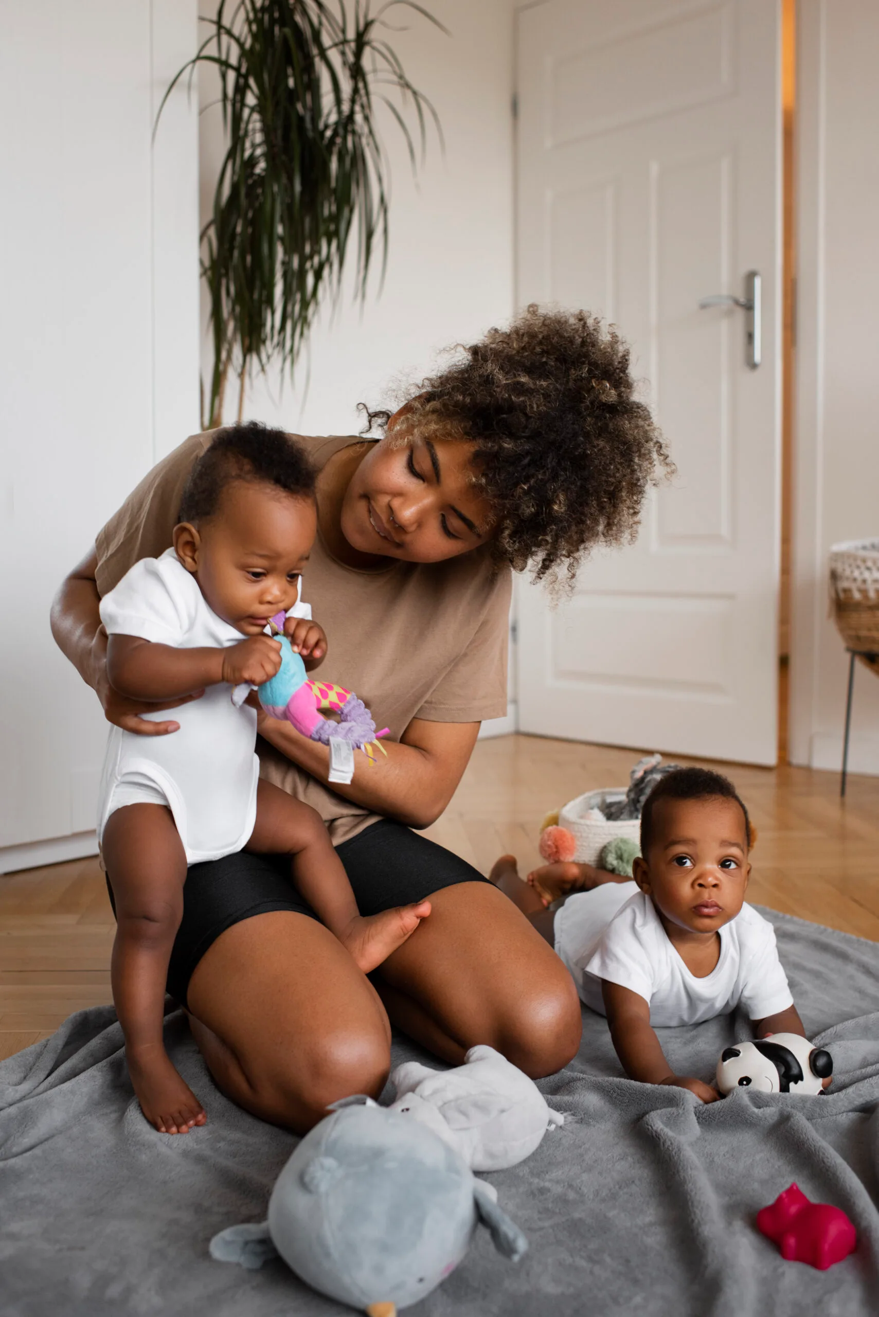 Femme noire jouant tendrement avec ses jeunes enfants